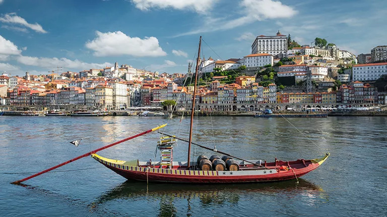 Traditional rabelo boat on the Douro River with the city scape of Porto in behind.