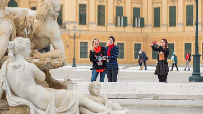 People looking at the statue monuments at the Schönbrunn Palace in Vienna.