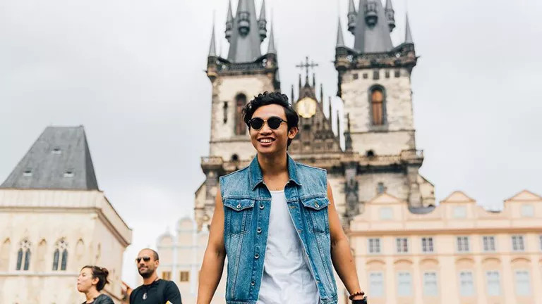 Man posing for photo outside Church of Our Lady before Týn in Prague