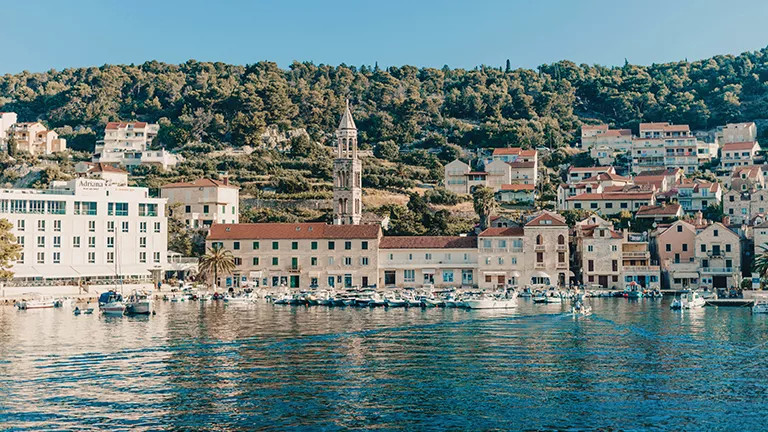 Buildings and towers on steep hillside making up Hvar’s town in Croatia.