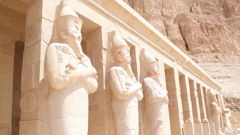 Statues standing on the outside of the Mortuary Temple of Hatshepsut in Egypt.