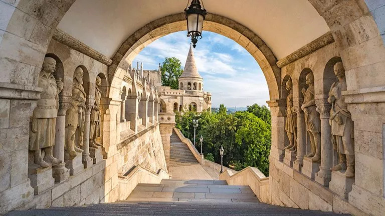 Tunnel built from stone, lined with statues at the Fisherman's Bastion in Budapest.