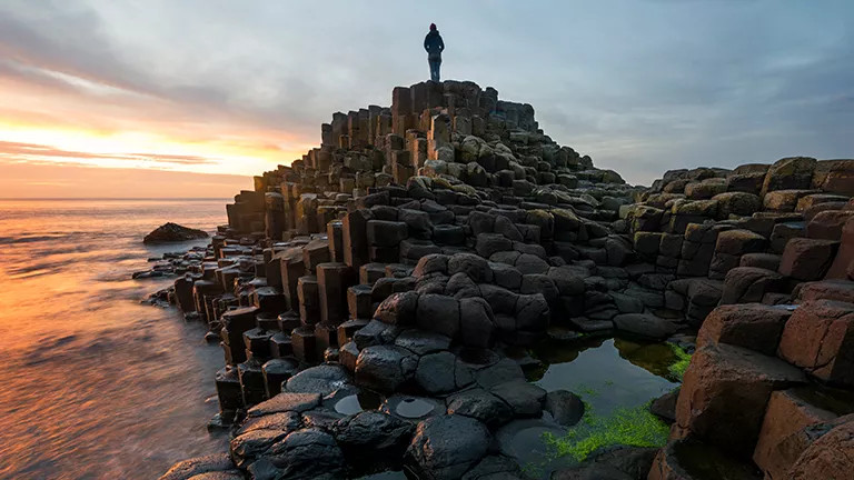 Person standing on the Giants Causeway in Northern Ireland.