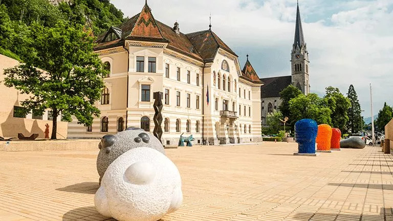 Coloured sculptures outside traditional building of the Government House of Liechtenstein.