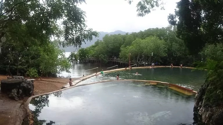 Multiple pools at Maquinit Hot Spring in Coron with a few people soaking in the hot water.