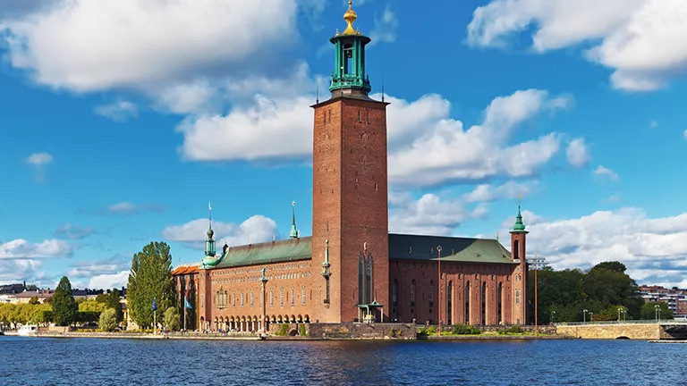 Brick building with tall tower, known as Stockholm City Hall.