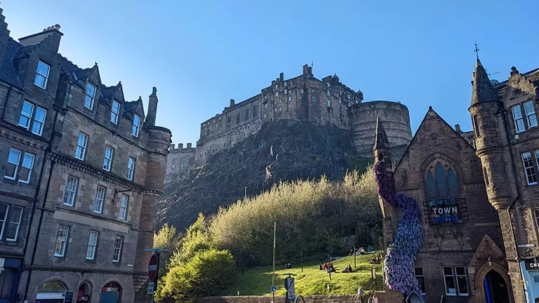 Edinburgh Castle on a hill above other stone buildings.