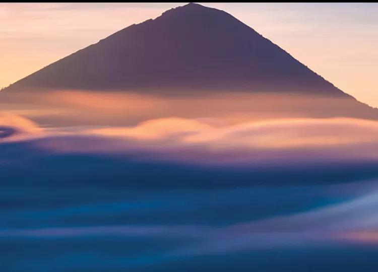 Bali's Mount Batur partially obscured by thin clouds.