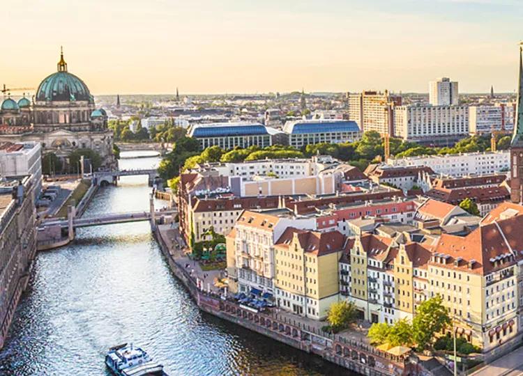 A view of the cityscape of Berlin, with the base of the Berliner Fernsehturm tower in view.