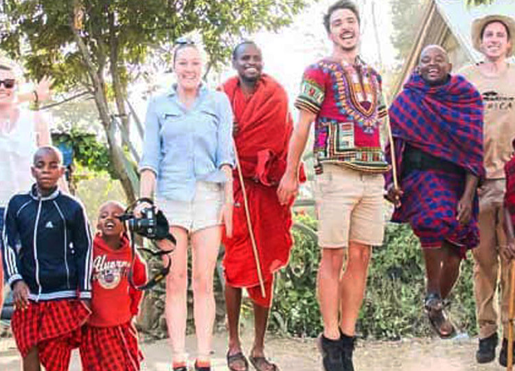 Topdeck tour group posing with African natives in traditional garb.