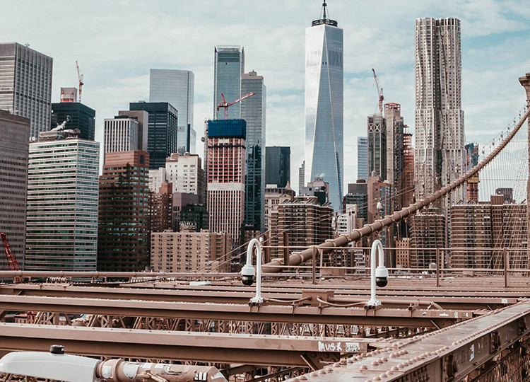 Topdeck tour group taking a stop on the Brooklyn Bridge, gazing out at the New York City skyline.