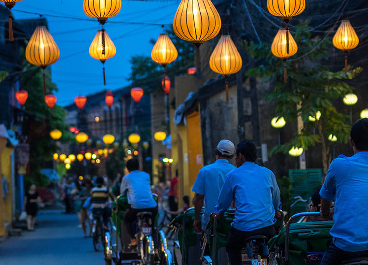 Locals cycle down the lantern lit streets of Hoi An in Vietnam.