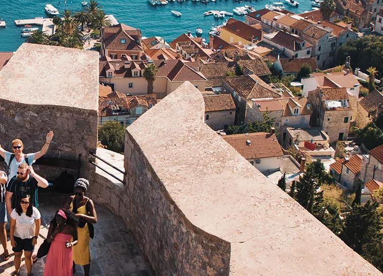 Topdeck tour group smiling for a group photo on the battlements of the fortress in Hvar.
