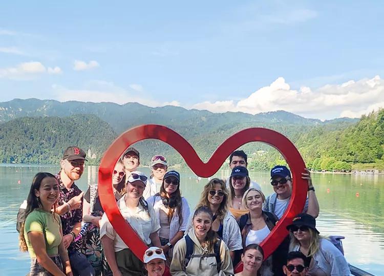 Topdeck travellers taking a group photo together at the Heart Arch in Slovakia.