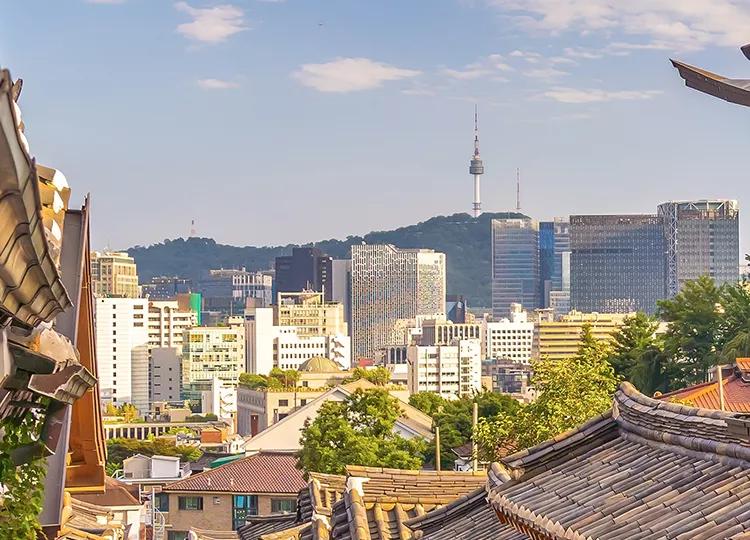 A view of Bukchon Hanok Village in South Korea, with the iconic observation tower in the distance.