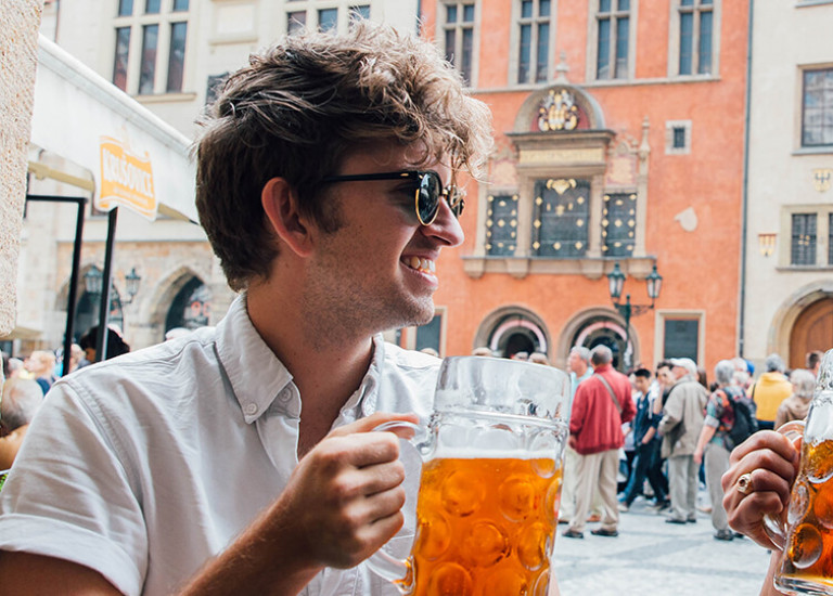Two Topdeck travelers sharing a pint of lager together in a bar in Prague.