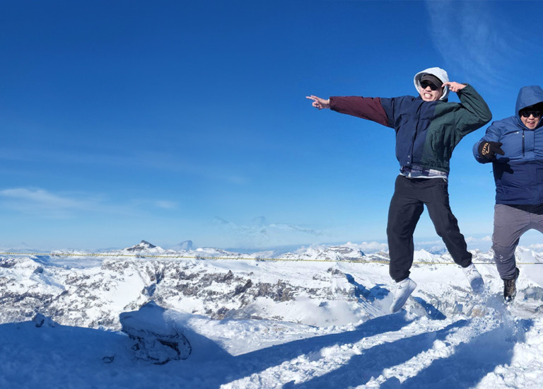 Three Topdeck Travelers jumping for joy while on a tour through the French Alps.