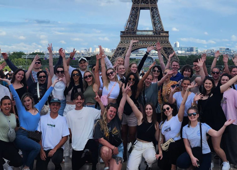 Topdeck group posing in front of Eiffel tower.