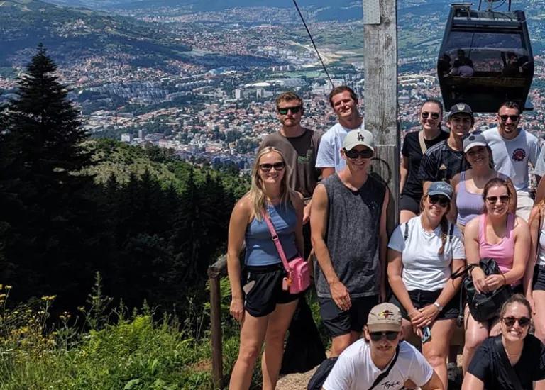 Topdeck travel group posing for a photo in front a of a grand vista during a trip to Europe.