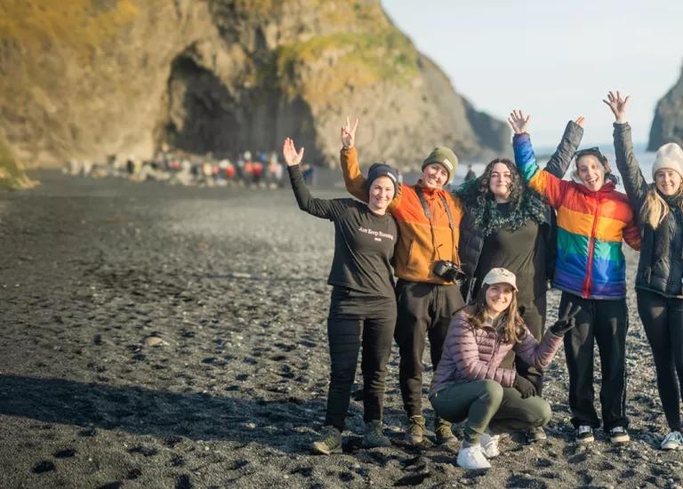 Group of Topdeck travellers posing for a picture during their trek across the black sand beaches of Iceland.