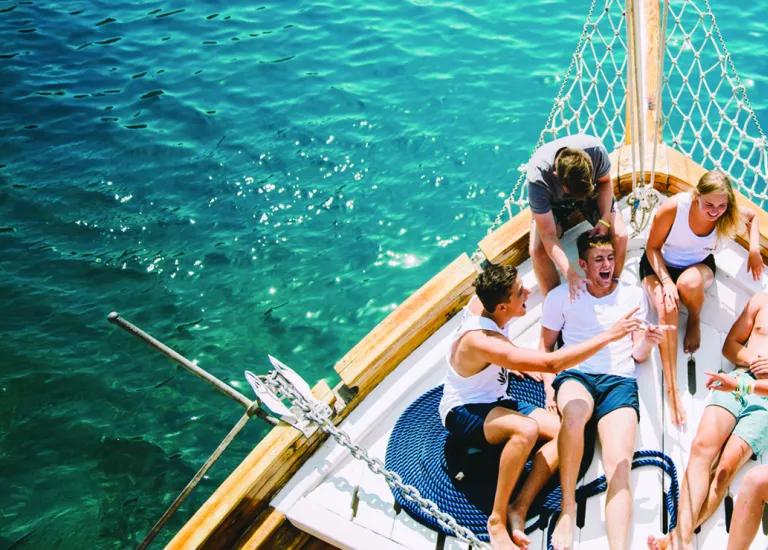 People laughing together at the bow of the boat.