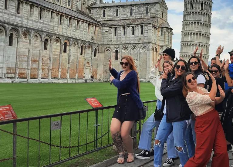 Topdeck travel group posing for a photo beside the Leaning Tower of Pisa.