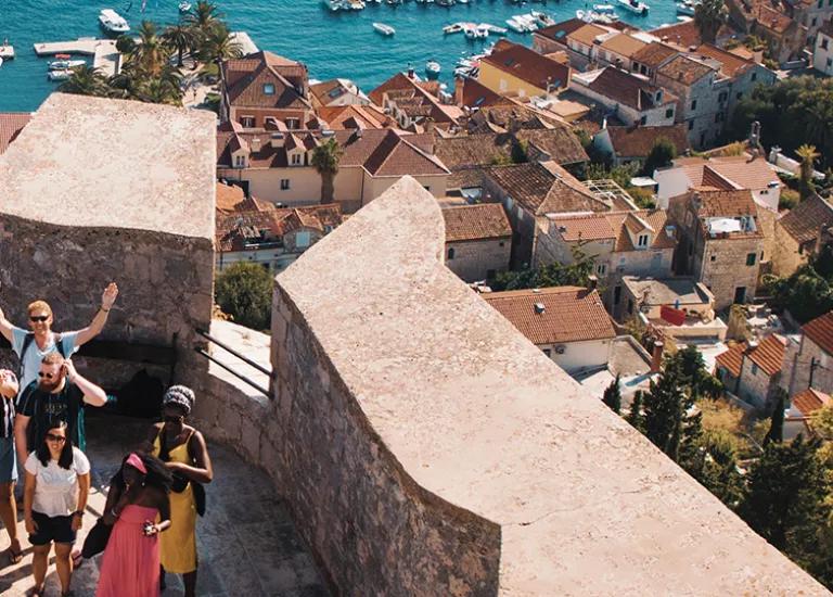 Topdeck tour group smiling for a group photo on the battlements of the fortress in Hvar.