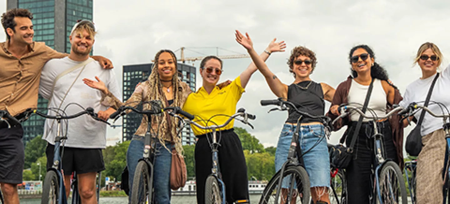 Group of people in a row standing over bikes with their hands in the air in Amsterdam.