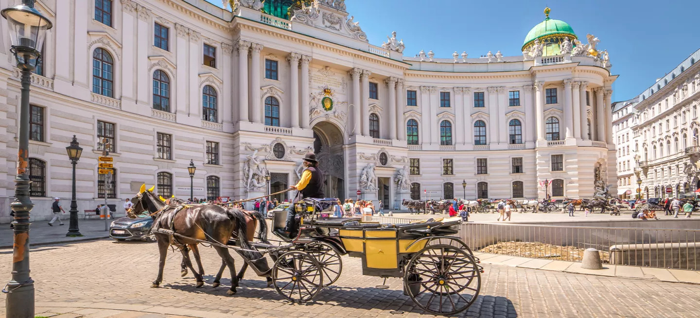 Horses and carriage outside a traditional building in Vienna, Austria.