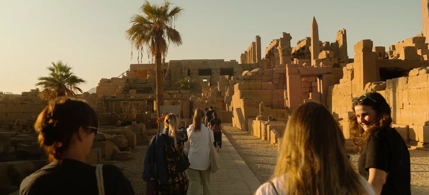 Group of people walking through the ancient ruins of the Karnak Temple in Luxor.