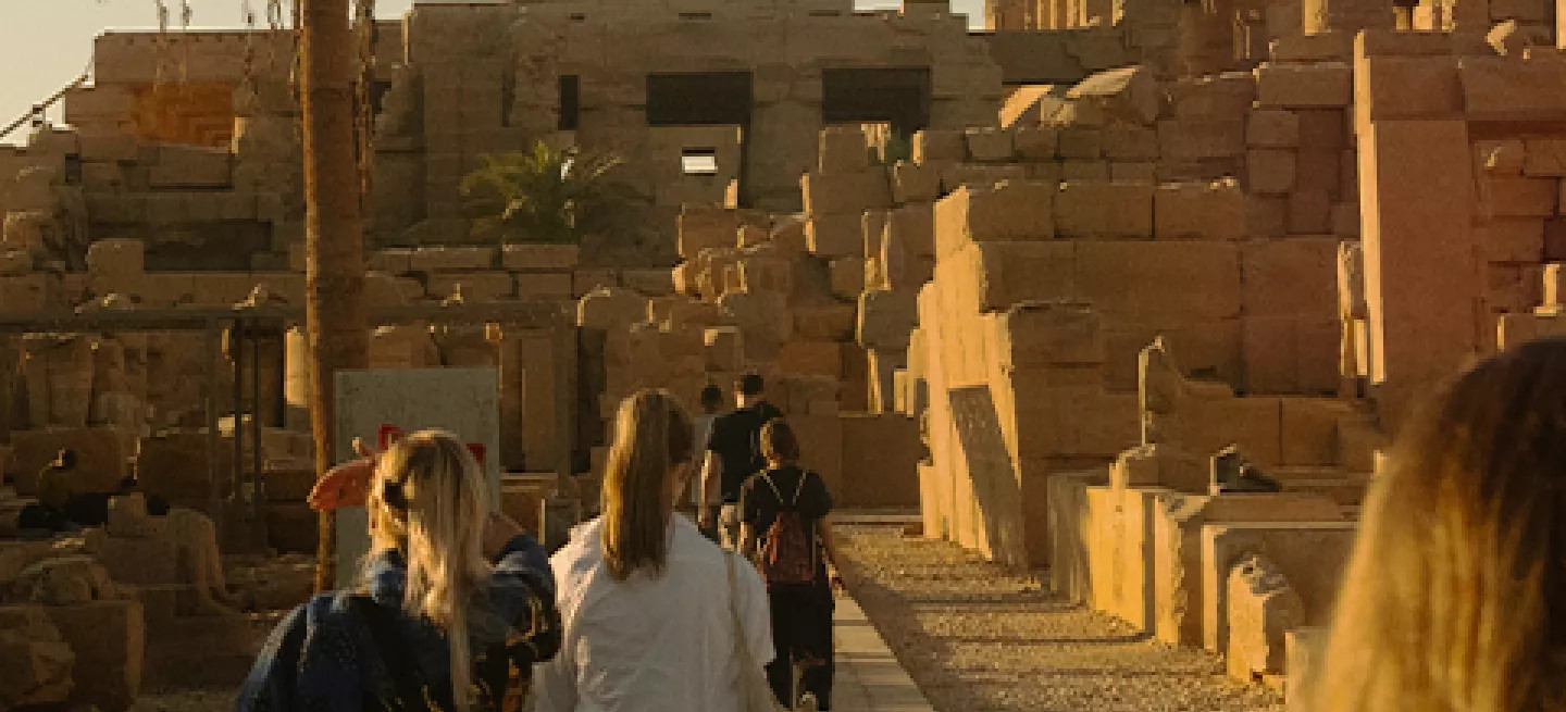 Group of people walking through the ancient ruins of the Karnak Temple in Luxor.