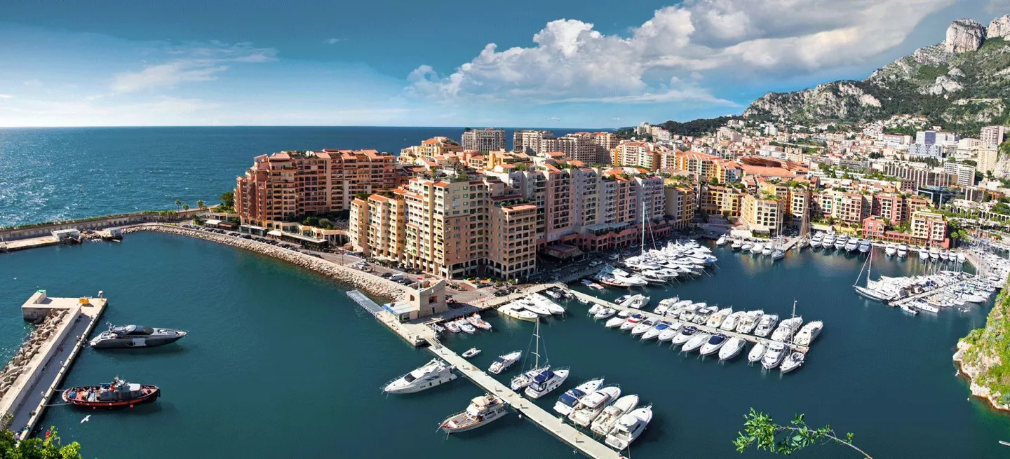 Habour lined with boats and skyline of Monte Carlo, Monaco.