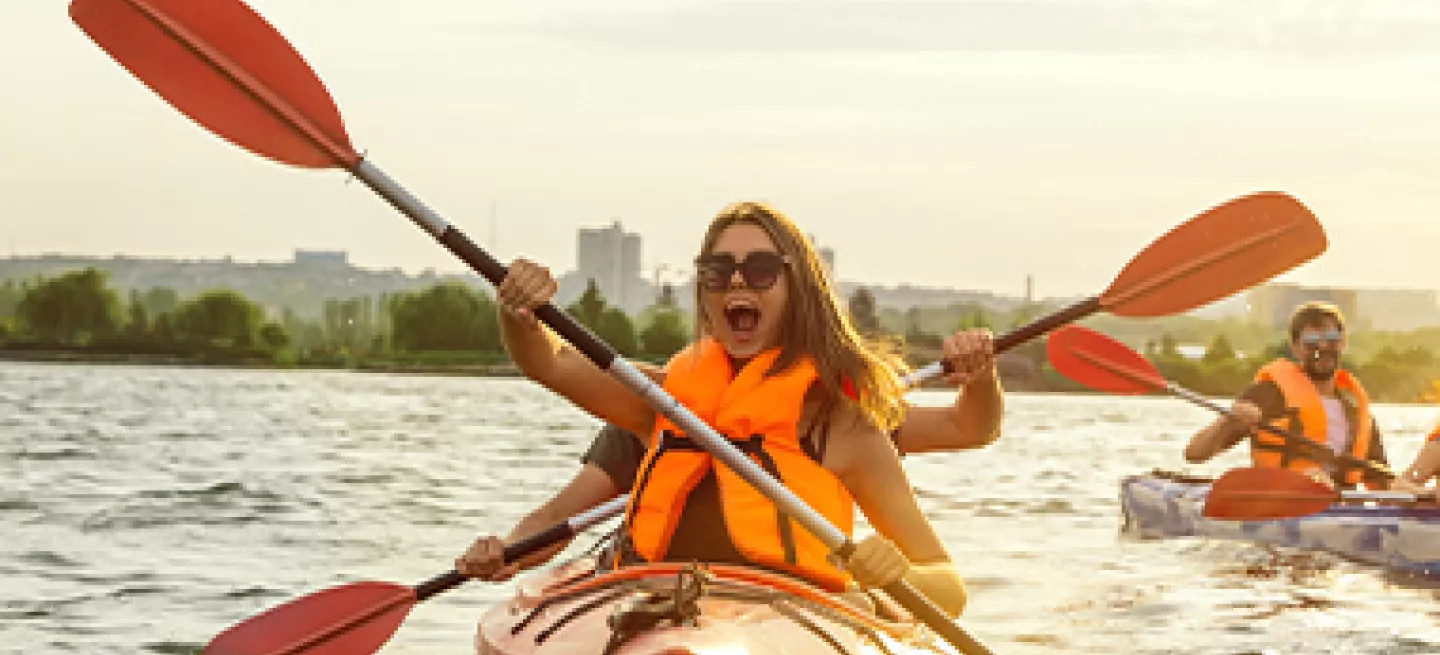 People kayaking with large paddles in Greece.