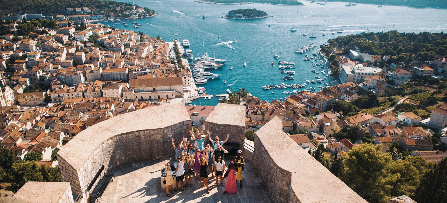 Group of travellers taking a photo by a marina in Europe