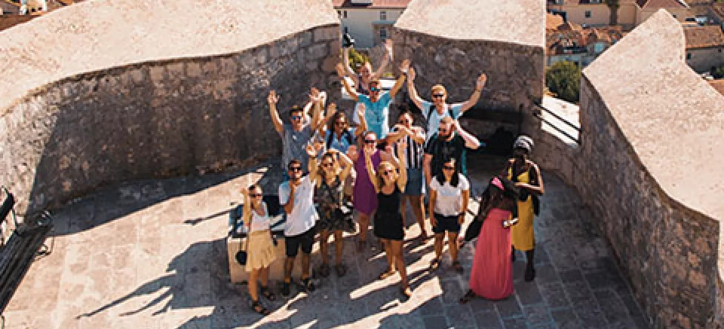 Group of travellers taking a photo by a marina in Europe