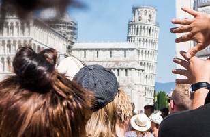 Topdeck Travel tour group heading to the Piazza del Duomo, with the Leaning Tower of Pisa in the background.