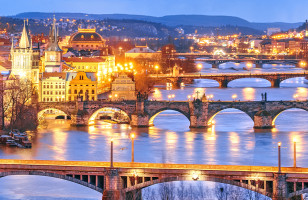 A view of the bridges leading out of Prague, lit up at night.