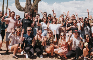 Group standing in the Arizona desert in front of a cactus.