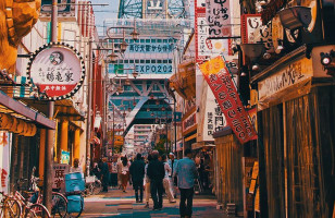 Advertisements for izakayas and bars adorn the busy Osaka street.