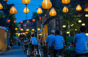 Locals cycle down the lantern lit streets of Hoi An in Vietnam.