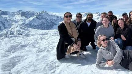 Topdeck tour group taking a group photo atop the Swiss Alps.