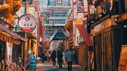 Advertisements for izakayas and bars adorn the busy Osaka street.