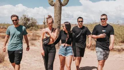 Topdeck Group standing in the Arizona desert in front of a cactus.
