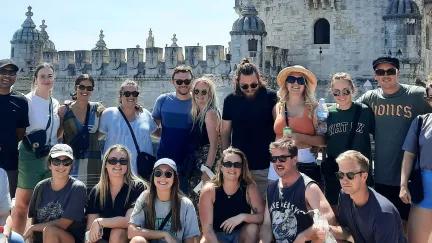 Topdeck tour group posing for a photo in front of Lisbon’s famous Torre De Belem Tower.