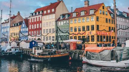 Boats and colorful houses line the docks of Nyhavn harbour in Copenhagen.