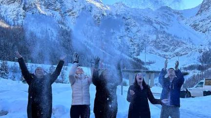 Topdeck group playing around and throwing snow in the air during a trip through the Swiss Alps.