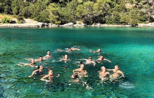 Topdeck travel group swimming and playing around in the crystal clear waters of the Croatian coast.