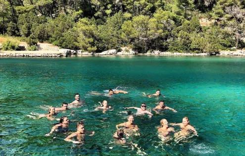 Topdeck travel group swimming and playing around in the crystal clear waters of the Croatian coast.