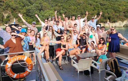 Topdeck travel group smile and laugh for a group photo during their boat trip around the Greek islands.
