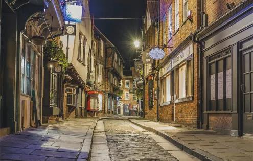 Streetlights shine on the old English stony streets of the Iconic Shambles in York.